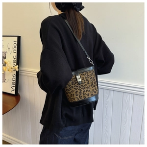 Detail of leopard print bucket bag featuring a silver metal twist lock and black leather trim