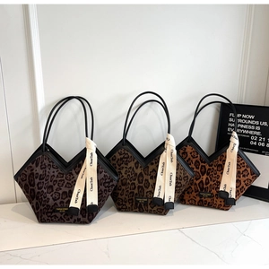 Dettaglio di tre borse tote leopardate con eleganti nastri di seta a contrasto