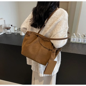 Detail der braunen Wildlederimitat-Tote-Bag mit passender Tasche, getragen im Café