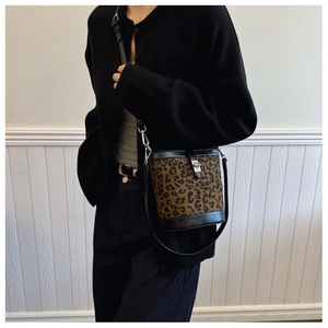 Detailed view of leopard print bucket bag with black leather and silver metal twist lock