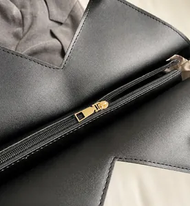 Dettaglio della cerniera dorata scorrevole su una borsa in pelle nera opaca di moda