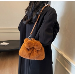Detail der flauschigen braunen Teddy-Eimertasche mit Kunstfell und Lederriemen