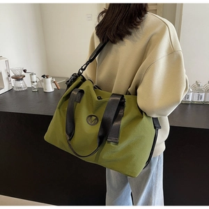 Close-up of olive green waterproof travel bag with M logo and durable black strap