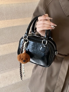 Chic black glossy bowling bag with cute plush teddy bear charm and striped strap