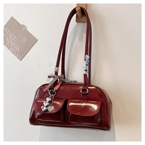 Detail der weinroten Lackledertasche mit zwei Fronttaschen und Herzanhängern