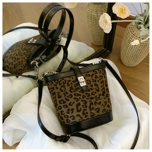 Detail of vintage leopard print bucket bag with silver twist lock on white fabric