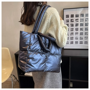 Detailweergave van grote metallic blauwe puffer shopper met gewatteerde nylon textuur