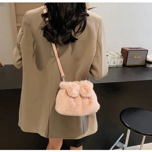 Detail der rosa Plüsch-Eimertasche mit Lederriemen in gemütlicher Café-Atmosphäre