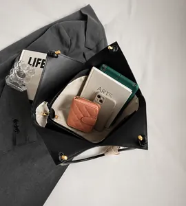 Vista dall'alto della capiente borsa tote nera con portafoglio rosa e accessori