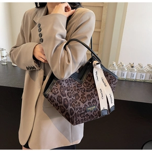 Dettaglio della borsa tote leopardata con manici neri e nastro decorativo alla moda