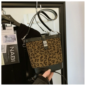 Macro detail of leopard print bucket bag featuring silver twist lock and black trim