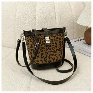 Detailed view of leopard print bucket bag with black leather trim and silver metal twist lock