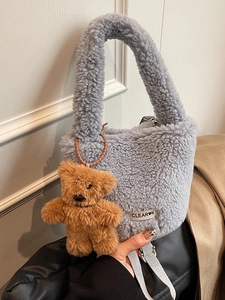 Chic grey faux shearling bucket bag with teddy bear charm and soft fuzzy texture