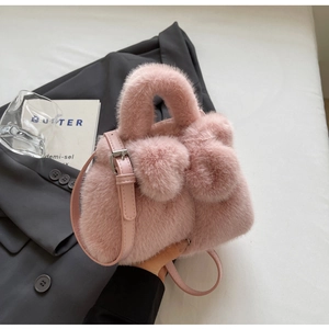 Detailaufnahme einer rosa Plüschhandtasche mit flauschiger Schleife und verstellbarem Ledergurt