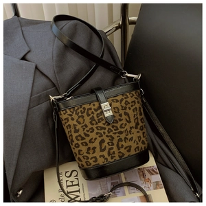 Close-up of leopard print bucket bag with metal twist lock and leather strap detail