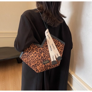 Dettaglio borsa leopardata con taglio a V e tracolla decorativa con lettere stampate
