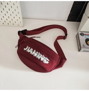 Close-up of burgundy sports chest bag with JIANING print and adjustable buckle strap