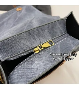Detail of smooth gold zipper on vintage blue denim fabric with high quality stitching