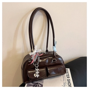Detailansicht der glänzenden braunen Bowling-Tasche mit Bandschmuck und Doppeltaschen