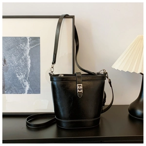 Macro view of black leather bucket bag with silver buckle in a modern lifestyle setting