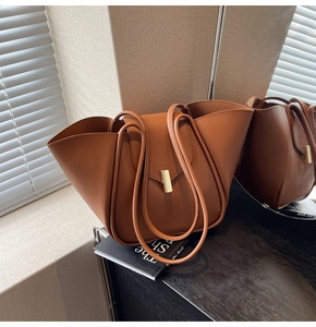 Détail d'un sac cabas en cuir caramel avec boucle dorée et fines bretelles élégantes
