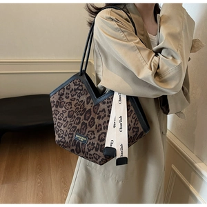 Borsa tote leopardata con apertura a V e tracolla decorativa su un completo trench coat