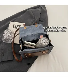 Detail view of the spacious inner compartment of the vintage denim and leather crossbody bag