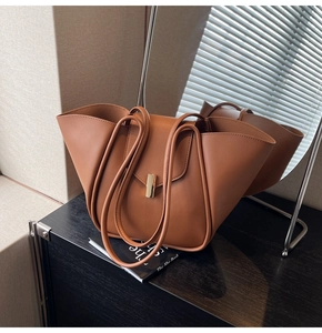 Gros plan d'un sac cabas en cuir fauve avec design plié et fermoir métallique élégant