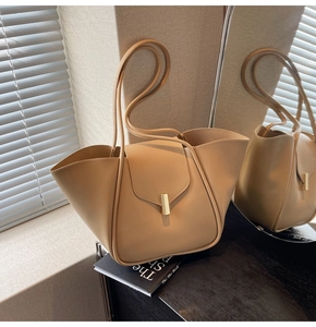 Gros plan détaillé du cabas beige avec boucle en métal doré et design à rabat