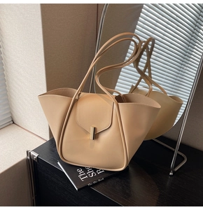 Gros plan d'un sac cabas beige avec texture cuir et boucle métallique rectangulaire dorée