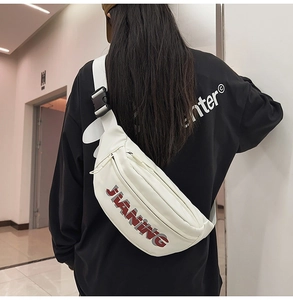 Close-up of a white JIANING crossbody bag featuring adjustable black straps and buckle