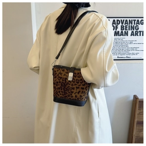 Detail of leopard print bucket bag with black leather trim and silver metal buckle