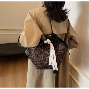 Vista dettagliata della borsa tote leopardata indossata da una modella in trench
