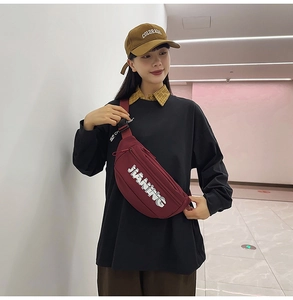 Detail of burgundy crossbody chest bag with JIANING logo and adjustable black strap