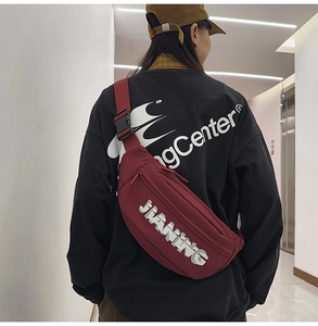 Detail of burgundy crossbody chest bag with adjustable strap and JIANING letter print