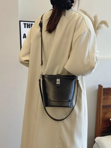 Elegant black leather bucket bag with silver metal swivel lock and long shoulder strap