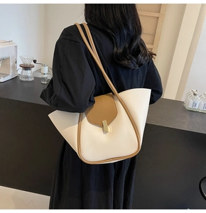 Détail du sac cabas avec boucle dorée et texture cuir dans un décor de café moderne