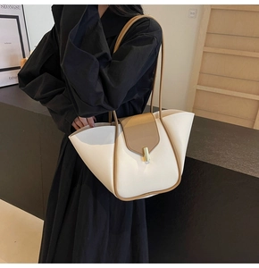 Détail d'un grand sac cabas élégant en crème et marron porté par un mannequin de mode