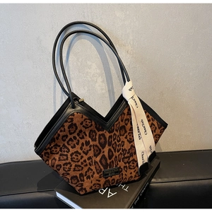 Dettaglio borsa shopper leopardata con manici in pelle nera e nastro decorativo alla moda