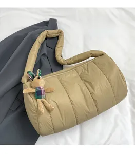 Close-up of quilted puffy shoulder bag in beige with a cute plush rabbit charm detail