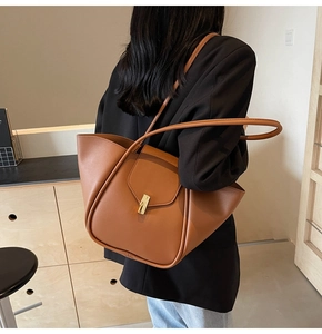 Vue détaillée d'un grand sac cabas en cuir marron avec une boucle métallique dorée élégante