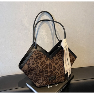 Dettaglio della borsa tote leopardata con finiture in pelle nera e foulard di seta
