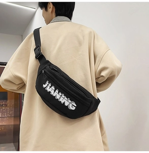 Close-up of black crossbody chest bag showing adjustable strap and plastic buckle detail