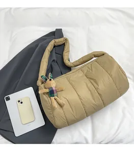 Quilted puffer bag in khaki with a cute rabbit charm shown next to an iPad for size reference