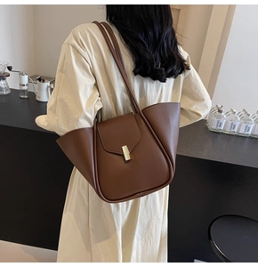 Détail du grand sac cabas marron avec boucle métallique et design d'ailes pliées