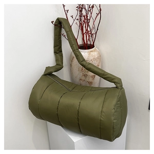 Macro view of olive green quilted puffer bag with soft down texture and padded strap