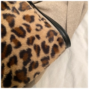 Gros plan sur la fausse fourrure léopard et les détails de la poignée en cuir du sac cabas