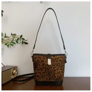 Close-up of leopard print bucket bag with black leather trim and silver metal twist lock