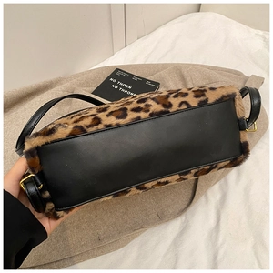 Détail du sac léopard en fausse fourrure avec base en cuir noir et boucles en métal doré