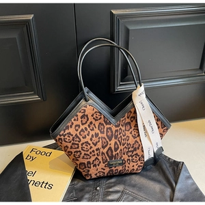 Dettaglio della borsa leopardata con bordi in pelle nera e sciarpa di seta decorativa